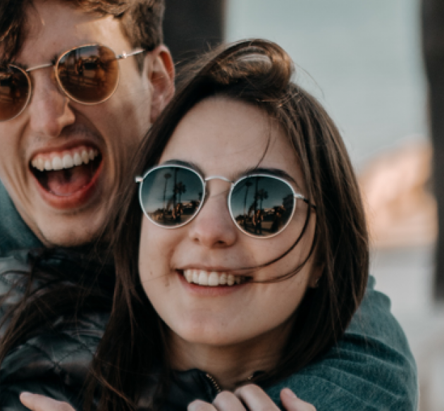 Jeune couple heureux qui portent des lunettes de soleil 