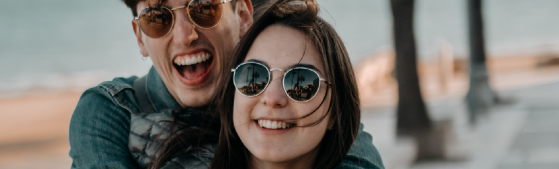 Jeune couple heureux qui portent des lunettes de soleil 